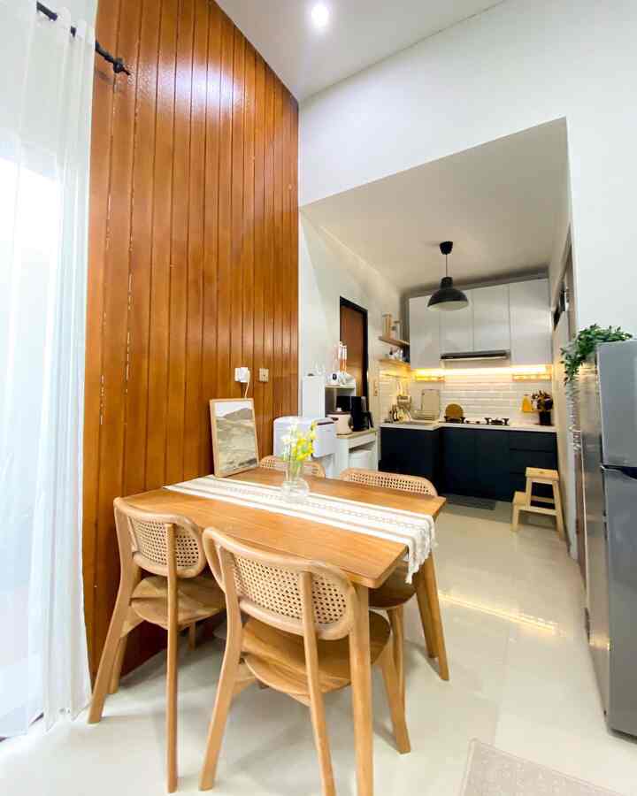 Warm wood tone and white 4-person dining room paired with a simple kitchen in a cozy home space