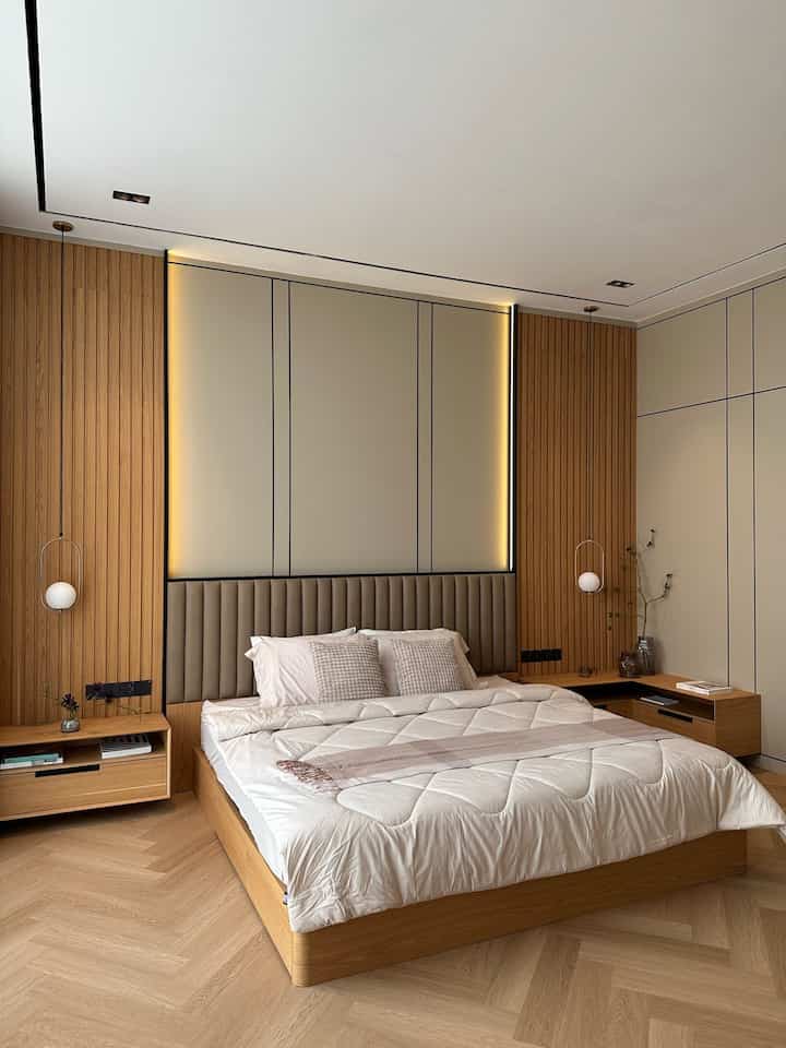 Beige and wood tone bedroom featuring central bed with pendant lights on both sides, natural modern style space