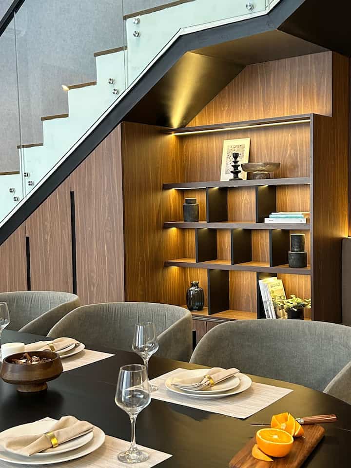 Warm wood tone natural modern dining room featuring wooden wall panels and LED lighting with a cozy atmosphere