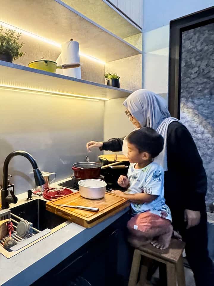 Dapur Ini Favorit Keluarga

Dapur ini menjadi pusat aktivitas keluarga, terutama di waktu malam setelah maghrib. Di sinilah momen memasak makan malam sambil mengajarkan anak-anak memasak. Anak-anak terlihat antusias dan hobi memasak, menjadikan dapur sebagai tempat belajar sekaligus bersenang-senang bersama.


Desain Dapur:
	•	Dominasi warna netral seperti abu-abu, nuansa kayu dan hitam memberikan kesan minimalis dan modern.
	•	Kabinet dinding serta rak terbuka dengan pencahayaan LED menciptakan atmosfer yang hangat.
	•	Material dapur menggunakan HPL & PVC serta mudah dibersihkan mendukung aktivitas sehari-hari keluarga.
	•	Meskipun tidak ada meja makan, dapur ini tidak kehilangan fungsinya sebagai ruang berkumpul. Kebiasaan makan bersama sambil duduk santai di lantai menjadi tradisi yang mempererat hubungan keluarga.

#Kitchenset #KitchenSetMinimalis #kabinettinggi #Plavonbeton #Solidsurface #CatAbuAbu #MomenDirumah #InspirasiDekorasi #RuanganFavorit