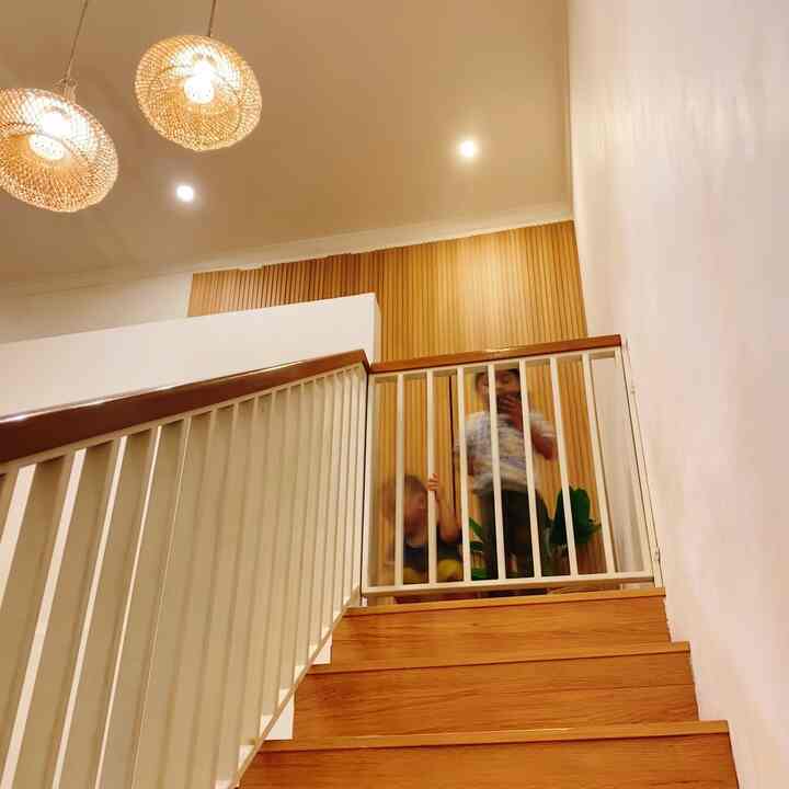 Natural brown and white toned stairs featuring a custom child safety gate creating a cozy secure area