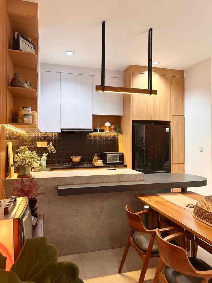 Natural modern wood tone kitchen and dining room featuring black refrigerator, white upper cabinets, and warm lighting creating cozy atmosphere