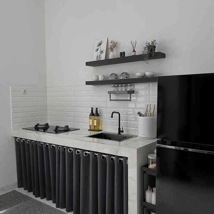 A compact kitchen space featuring white walls and black kitchen furniture, highlighting practical storage ideas.