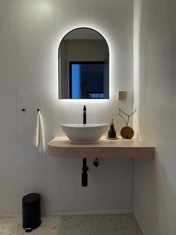 Modern bathroom sink area in white and wood tones, featuring a simple and elegant design