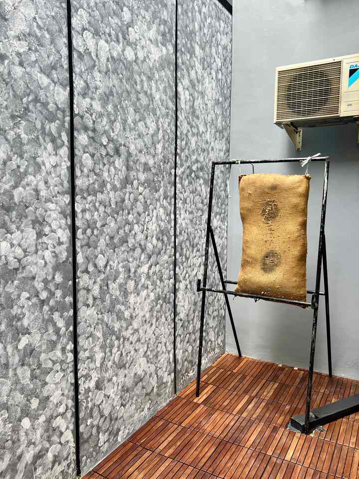 Void rumah memiliki ukuran 1x6 meter dan didesain multifungsi untuk berbagai kebutuhan. Area ini memiliki lantai yang sebagian besar menggunakan decking tile, memberikan tampilan natural sekaligus nyaman untuk dipijak.

Beberapa fungsi utama void ini meliputi:
	1.	Tempat mencuci piring, yang menjadi area utilitas praktis.
	2.	Tempat latihan panahan, menciptakan ruang khusus untuk menyalurkan hobi.
	3.	Area bersantai, memungkinkan anggota keluarga menikmati suasana santai dengan udara segar.
	4.	Sirkulasi udara, menjadikan void sebagai elemen penting dalam menjaga ventilasi alami rumah.

Selain itu, void ini juga memiliki lampu outdoor dengan pencahayaan warm, menciptakan suasana hangat dan nyaman di malam hari. Di sudut lain terdapat ruang untuk menyimpan alat kebersihan, menjaga agar area tetap rapi dan terorganisir. Kombinasi fungsionalitas dan estetika menjadikan void ini pusat aktivitas sekaligus penunjang kenyamanan rumah Anda. 
#VoidMinimalis
#RuangFungsional
#DekorasiOutdoor
#AreaSirkulasiUdara
#LampuWarm