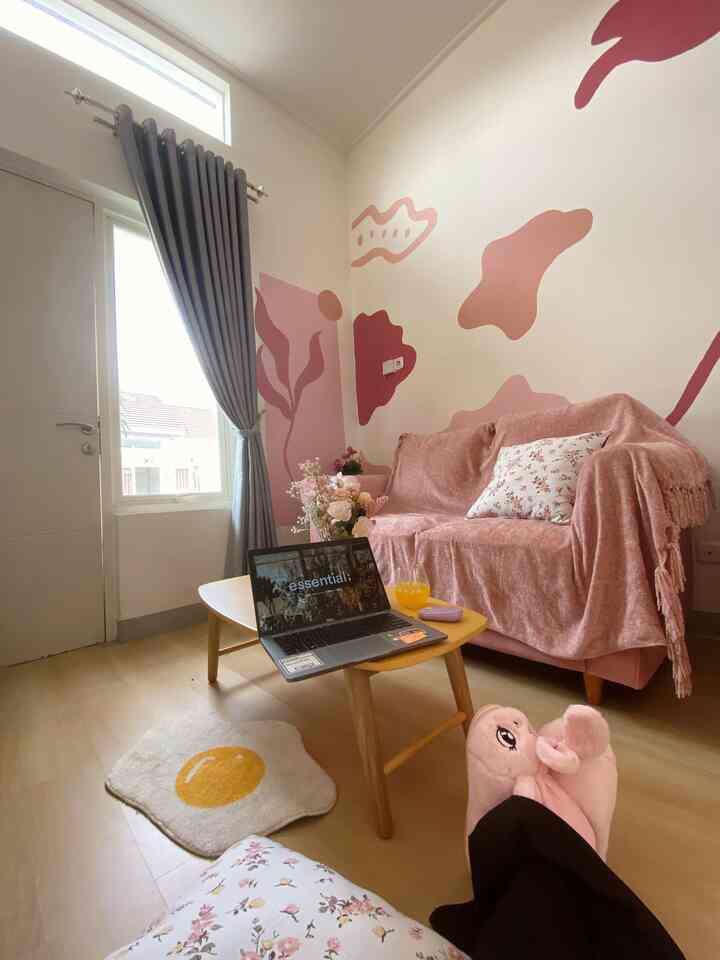 A compact living room in pink and natural tones featuring adjustable furniture and wall decor, creating a cozy and Instagrammable atmosphere