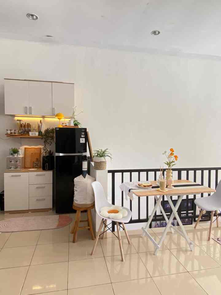 White-toned small kitchen and dining room featuring minimal furniture and a cozy home cafe atmosphere