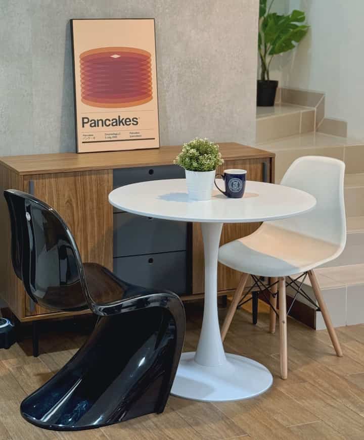 A compact dining room featuring white and wood tones with a round dining table, chairs, and cozy atmosphere.