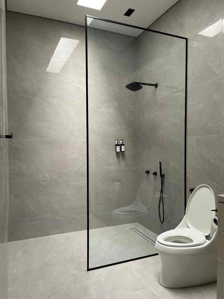 Transformasi kamar mandi ini dimulai dari sebuah ruang kosong yang belum tersentuh hingga menjadi ruang yang modern dan elegan. Prosesnya penuh dengan perhatian terhadap detail, mulai dari pemilihan material hingga sentuhan akhir yang membuatnya nyaman digunakan.

Langkah-langkah transformasi:
	1.	Persiapan Awal
Ruang awal hanya berupa dinding beton kasar. Kami memastikan struktur dan saluran pipa sudah sesuai sebelum memulai renovasi besar. Untuk ventilasi, skylight dipertahankan agar cahaya alami tetap masuk.
	2.	Pemilihan Material
Kami memilih ubin porselen berwarna abu-abu muda dengan tekstur halus untuk dinding dan lantai, menciptakan kesan luas dan mewah. Material ini juga mudah dibersihkan dan tahan lama.
	3.	Fitur Kamar Mandi
	•	Shower dengan rain shower hitam matte dan partisi kaca frameless memberikan kesan minimalis.
	•	Toilet putih modern dipilih agar sesuai dengan tema netral.
	•	Sistem drainase linear di bawah shower memastikan air mengalir dengan baik tanpa meninggalkan genangan.
	4.	Detail Kecil yang Berarti
	•	Aksesori seperti holder sabun hitam matte dipasang untuk menjaga konsistensi desain.
	•	Pencahayaan buatan dari lampu LED dilengkapi dengan skylight agar suasana tetap terang di siang maupun malam hari.

Transformasi ini bukan hanya tentang estetika, tapi juga fungsi yang maksimal. Apa menurutmu ruang ini bisa jadi inspirasi untuk renovasi rumahmu? Bagikan ceritamu juga!

#renovasikamarmandi #bathroommakeover #inspirasikamarmandi #showerhead #rainshower #tiles #bathroomtiles #glasspartition #bottle #glass #bathroom #shower