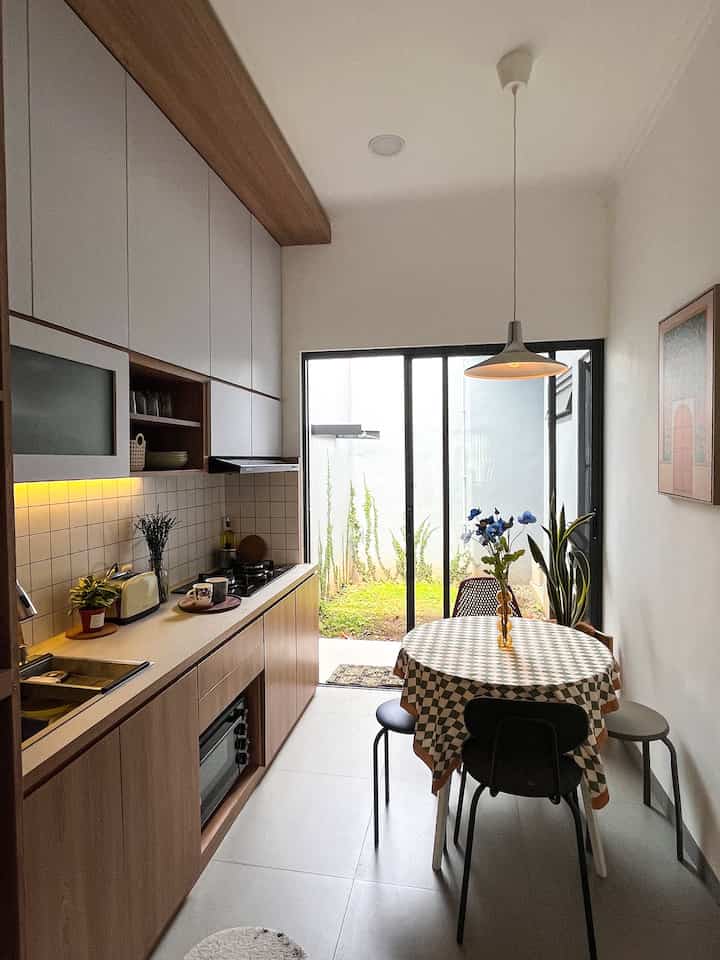 White walls and wood-tone kitchen cabinets with a round dining table in a modern kitchen space