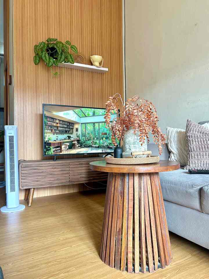 Natural wood-tone living room featuring a round coffee table and sofa with a cozy atmosphere