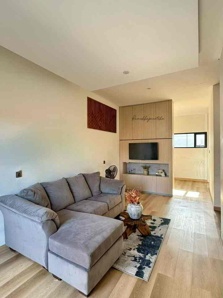 Natural-toned compact living room featuring a gray sectional sofa, neat and functional atmosphere