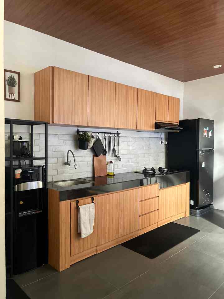 A clean single-line industrial kitchen featuring brown wood tones and black accents