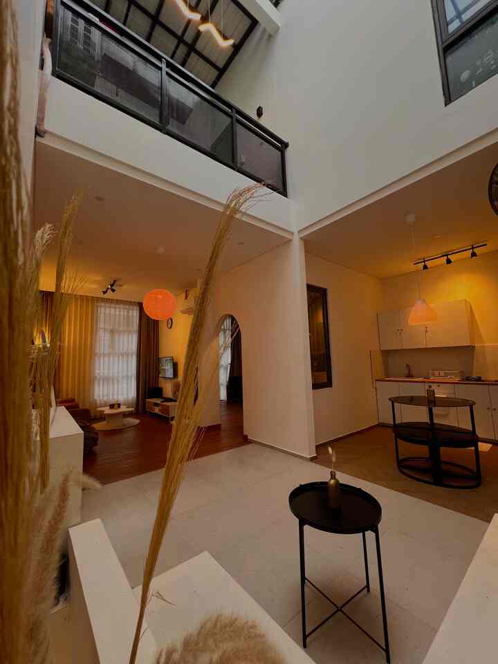 Open space living room and dining area with warm lighting and brown wood tones, featuring a modern natural interior
