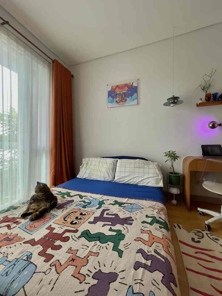 Natural-colored bedroom with white walls, featuring blue bedding and a desk, creating a cozy atmosphere