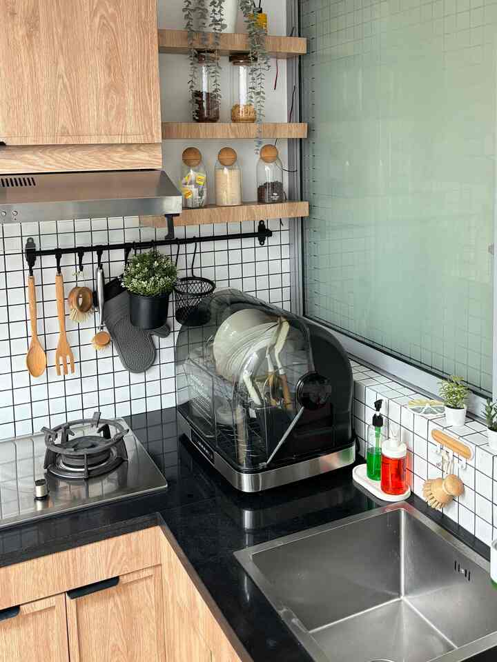 Clean kitchen space with black marble countertop and wood tone cabinets