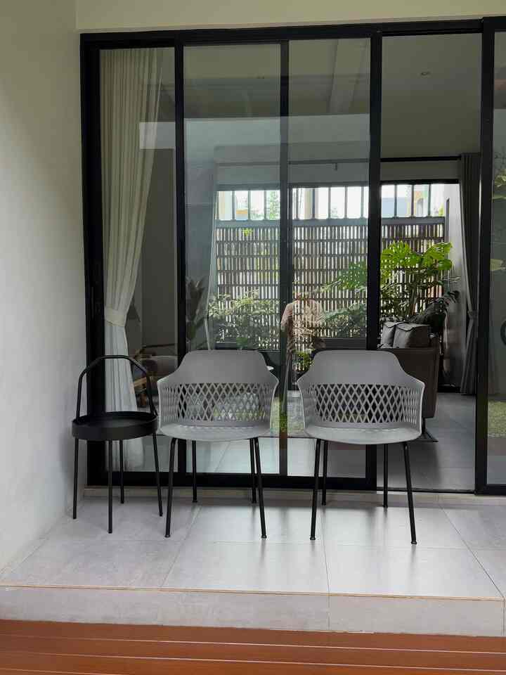 Gray and black toned balcony featuring two gray chairs and a black side table in a neat setting