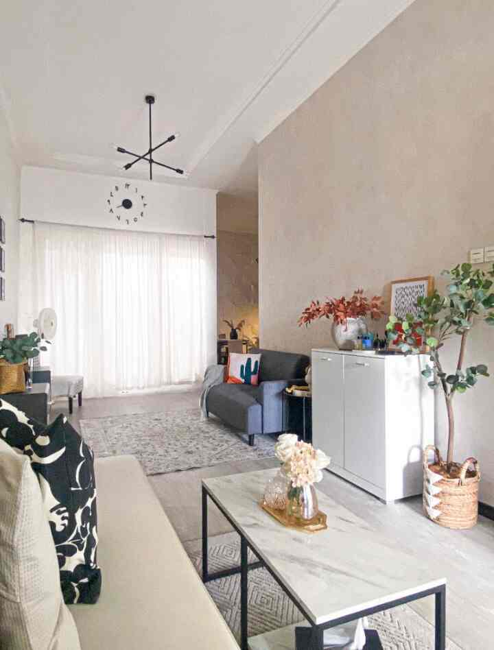 White and gray toned living room featuring a two-seater sofa and coffee table in a neat and spacious open space