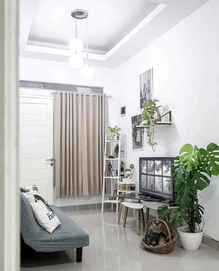A white and gray tone living room featuring a gray sofa, beige curtains, and a cozy cat corner