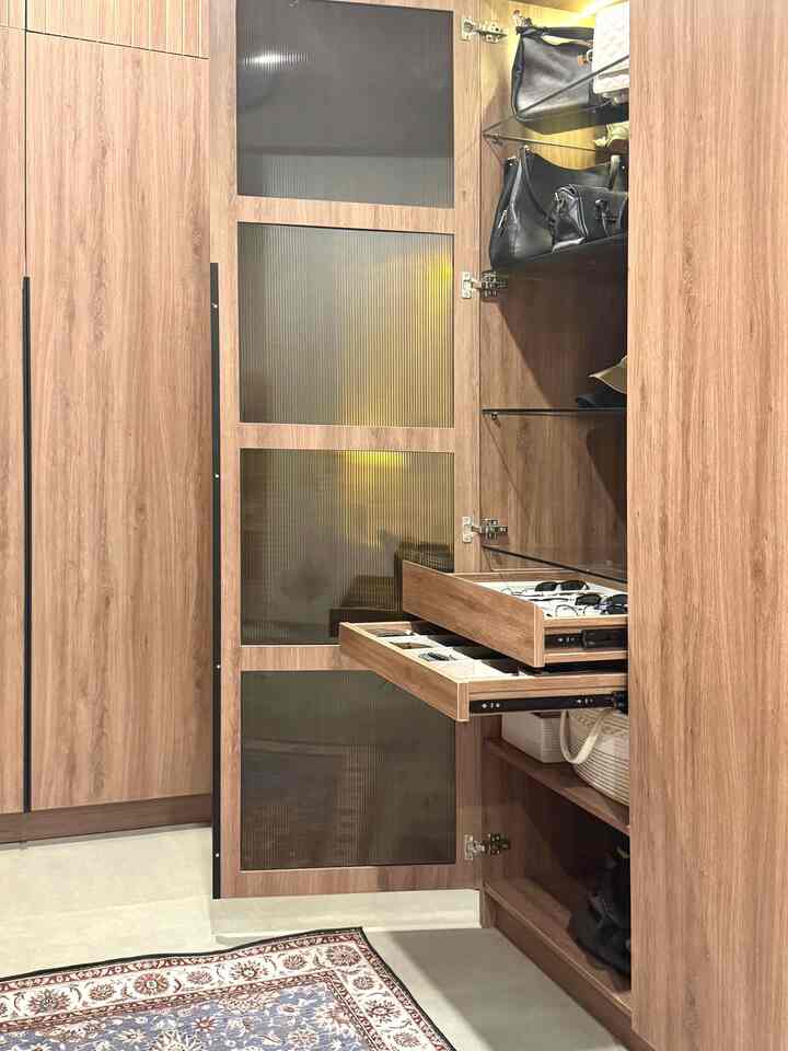 Entrance space featuring natural wood tone storage cabinets with organized shelves for shoes and bags