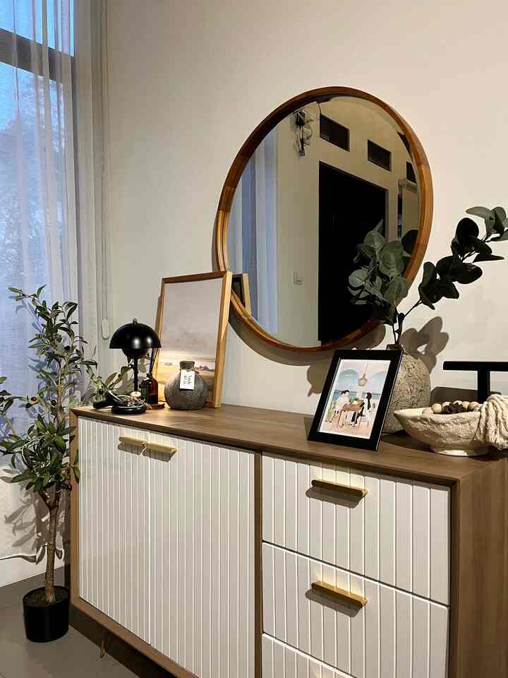 Menurutku area credenza ini jadi salah satu area yang punya look elegan di #rumahmaknaa. 

Beberapa hal yang menurutku area ini bisa terlihat elegan adalah :
- Cat rumah berwarna putih
- Menggunakan perpaduan warna yang netral dengan sedikit sentuhan gold. 
- Menggunakan cermin besar dengan list kayu solid ✨
- Menggunakan lampu warna warm white bikin nuansa ruangan  jadi berasa lebih cozy dan mahal. 
- Memilih dekorasi dengan wall decor dengan gambar simple dan warna senada juga vas rustic. Meski harganya ga mahal tapi bisa keliatan mahal 🫶🏽

#CatRumahMewah #CredenzaJapandi #Kabinet #cermindinding #CerminKayu #ArtificialPlant #OliveTree #ElegantOnBudget #DesainRumahElegant #SederhanaMewah

