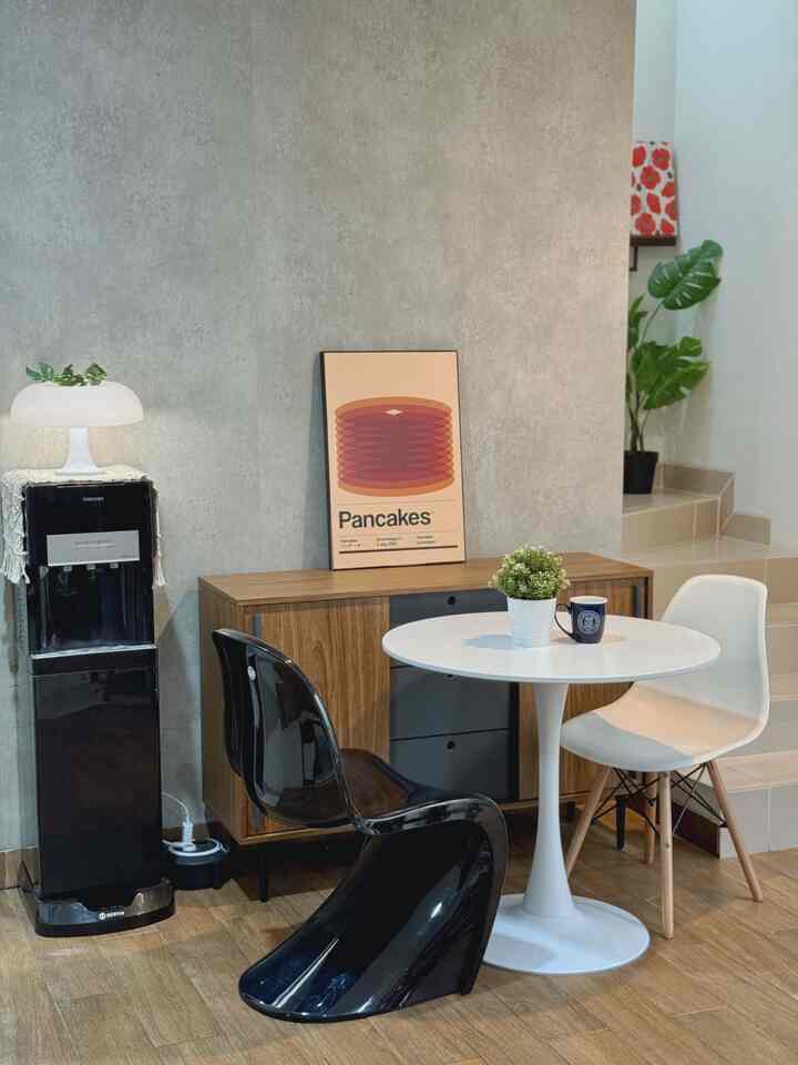 Natural-toned dining room featuring a round table, mixed modern chairs, and wood cabinet creating a cozy atmosphere