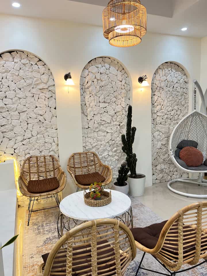 Natural living room featuring light brown rattan furniture and natural stone wall with warm ambiance