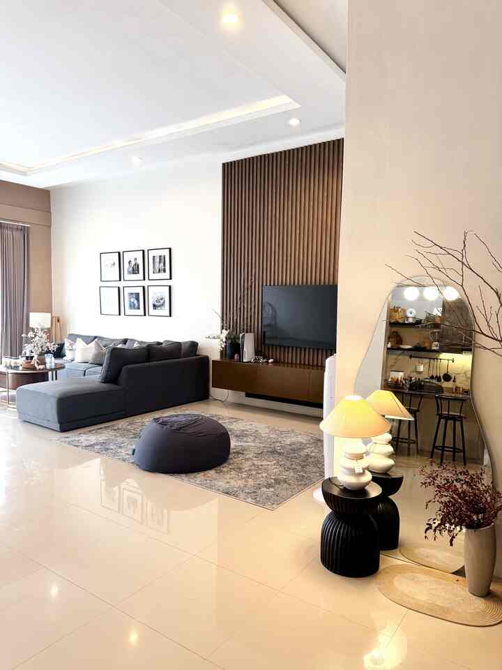 Modern living room with beige floor and wood tone wall panel featuring gray sectional sofa and bean bag creating a cozy atmosphere