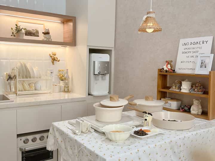 White and wood tone kitchen space featuring minimalist storage and pet accessories creating a warm, cozy atmosphere
