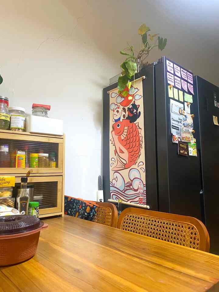 Brown-toned kitchen and dining table featuring wall decor and a black refrigerator in a cozy space