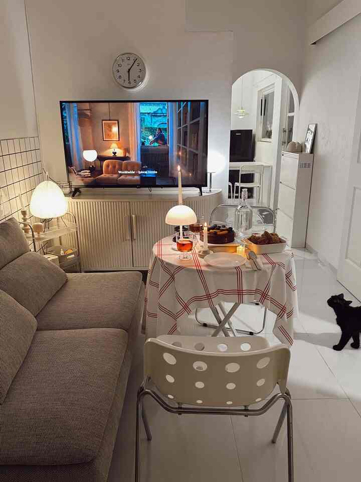 White and gray toned living room featuring table and sofa, creating a simple and cozy home party atmosphere