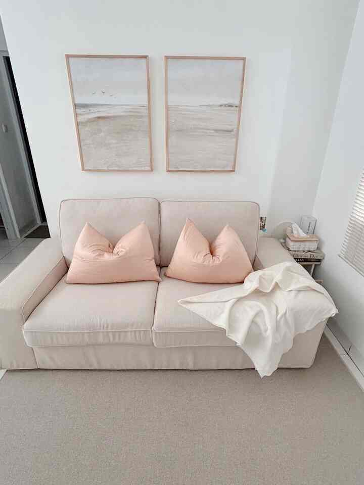Soft beige-toned living room featuring a beige sofa with pale pink pillows, creating a cozy atmosphere