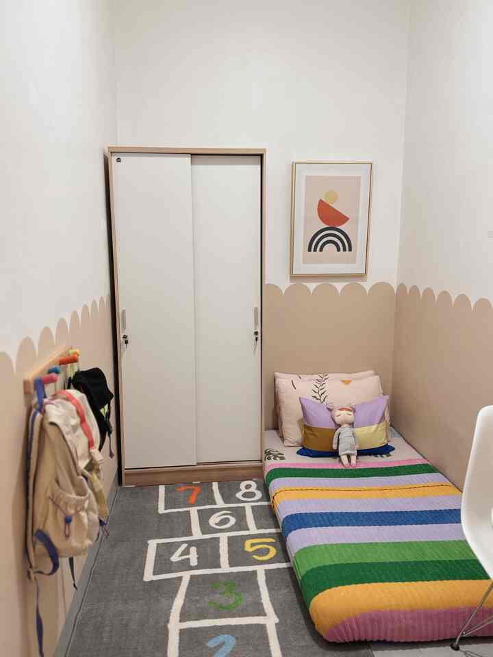 Beige walls and gray carpet in a kids' room featuring a low bed and closet in a cozy setting