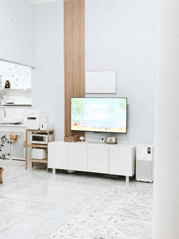 Bright white-toned living room featuring natural wood panel and TV stand in a modern setting