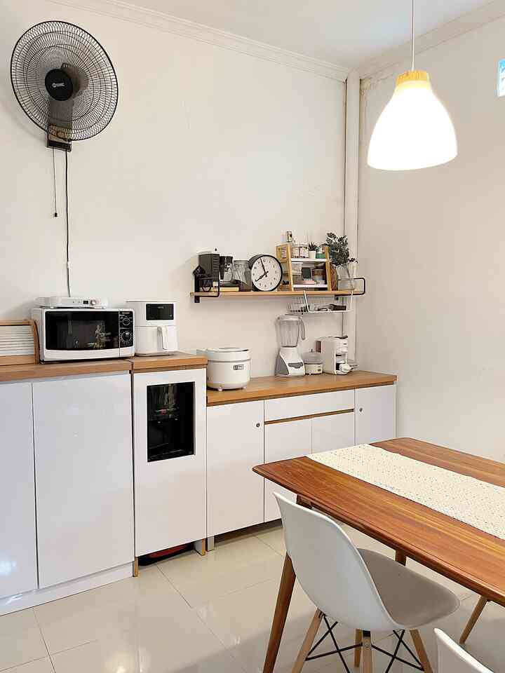 A white and wood tone dining room featuring a pendant light, clean dining table and chairs with a minimal and natural atmosphere