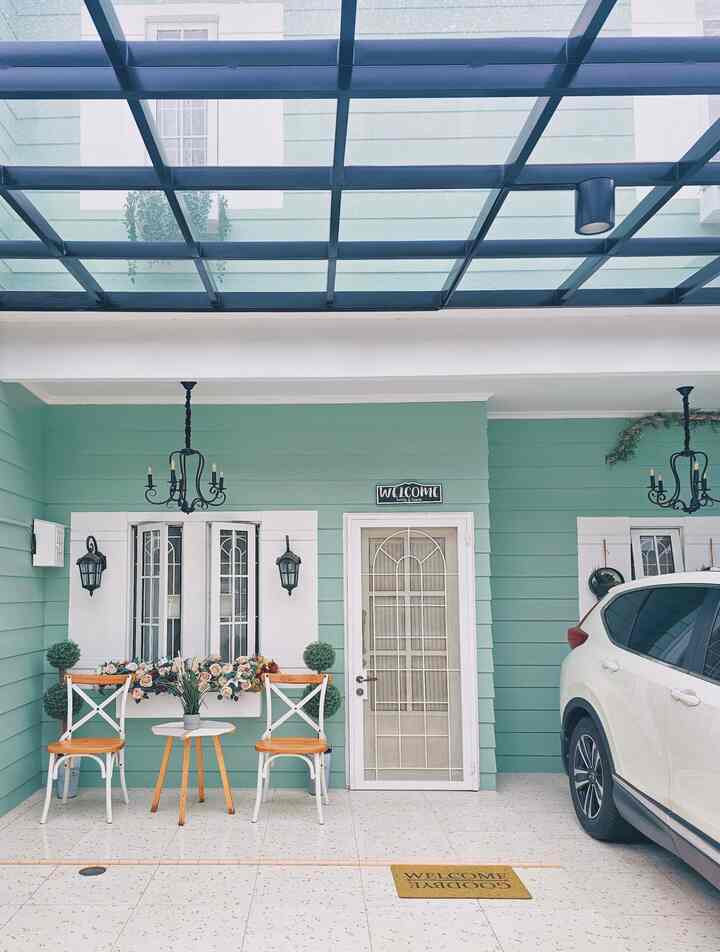 White and green toned entrance space featuring wooden chairs and a small table in a cozy patio
