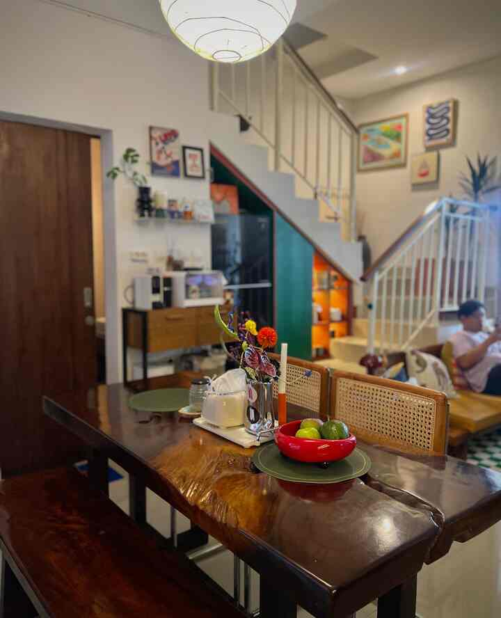 Natural 4-person dining room and living space featuring brown wooden dining table and chairs against white walls