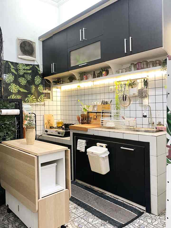 Assalamu’alaikum everyone✨🫶🏻
Cerita sedikit soal dapur, jadi dapur ini memang sudah terdapat kitchenset bawaan dari pemilik sebelumnya. Sebenarnya ada plus dan minusnya, Alhamdulillahnya kami tidak perlu mengeluarkan budget besar untuk pembuatan kitchenset, hanya saja kami tidak bisa menentukan model yang kami inginkan.

Maka dari itu cara kami styling kitchen dan dining di area dapur mungil ini supaya lebih estetik dan fungsional tentunya, yaitu :
⚒️Makeover low budget dengan mengganti warna kitchenset menggunakan stiker PVC hitam dan dinding keramik menggunakan stiker dapur backsplash motif kotak-kotak. Pemilihan warna netral ini memudahkan untuk mix and match dengan dekor lain. 

🪵🍃 Penambahan sentuhan kayu dan tanaman agar suasana terasa lebih cozy dan segar.

🪑 Memaksimalkan area dengan meja lipat multifungsi di area terbatas.

✨ Menambah beberapa dekorasi kecil agar dapur tidak terasa monoton.

Semoga tips ini bisa menginspirasi kalian yang punya dapur dengan ruang terbatas atau ingin memperbarui tampilan dapur dengan budget yang terjangkau!🫶🏻

#MakeOverDapur #StylingDapur #DapurImpian #KitchenSet #kitchensetminimalis #MejaMakanLipat #MejaMakanMinimalis #dapurminimalis #DapurMungil #DapurSegaris 