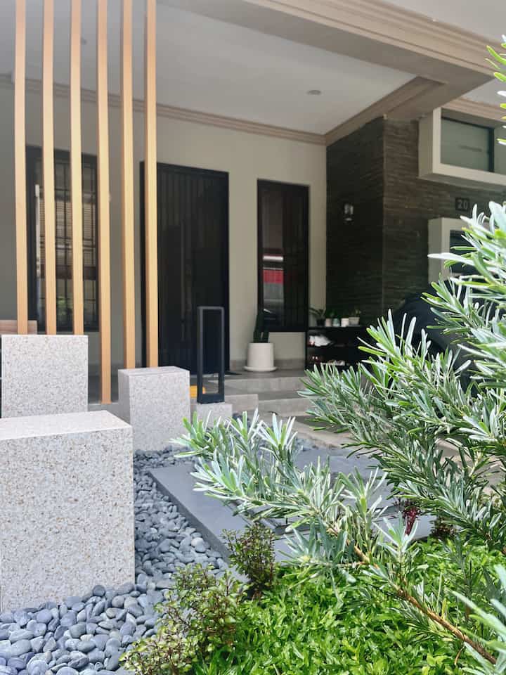 Fasad rumah bawaan developer dengan style early 2013-an, tidak banyak diubah karena mengikuti ketentuan yang berlaku. Kami hanya menambahkan elemen dekoratif seperti kisi-kisi wpc pada teras, mengganti keramik lantai menjadi granit, membuat bench di teras, serta menata taman kecil di depan rumah dengan konsep taman kering.

#carportbatuandesit #inspirasicarport #stylecarport #carportrumah #carportminimalis #kisikisiteras #lamputaman #tamankecil #fasaddeveloper #terasminimalis