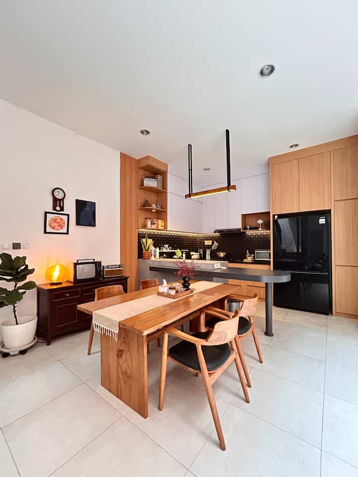 Masih dalam konsep japandi mix mid century warna yang diterapkan adalah hitam,putih dan kayu natural, serta aksen lampu warm white untuk ambience. 
Ide desain didapat dari pinterest. Untuk meminimalisir kesan berantakan semua kabinet dibuat tertutup dan full ke ceiling untuk memaksimalkan storage. 
Sedikit sentuhan tanaman tropical untuk memasukan nuansa alam pada ruangan.

#MejaMakanJapandi #DapurMinimalis #KitchenSet #IslandMinimalis #MejaMakanKayu #MakeOverDapur #StylingDapur #DapurImpian