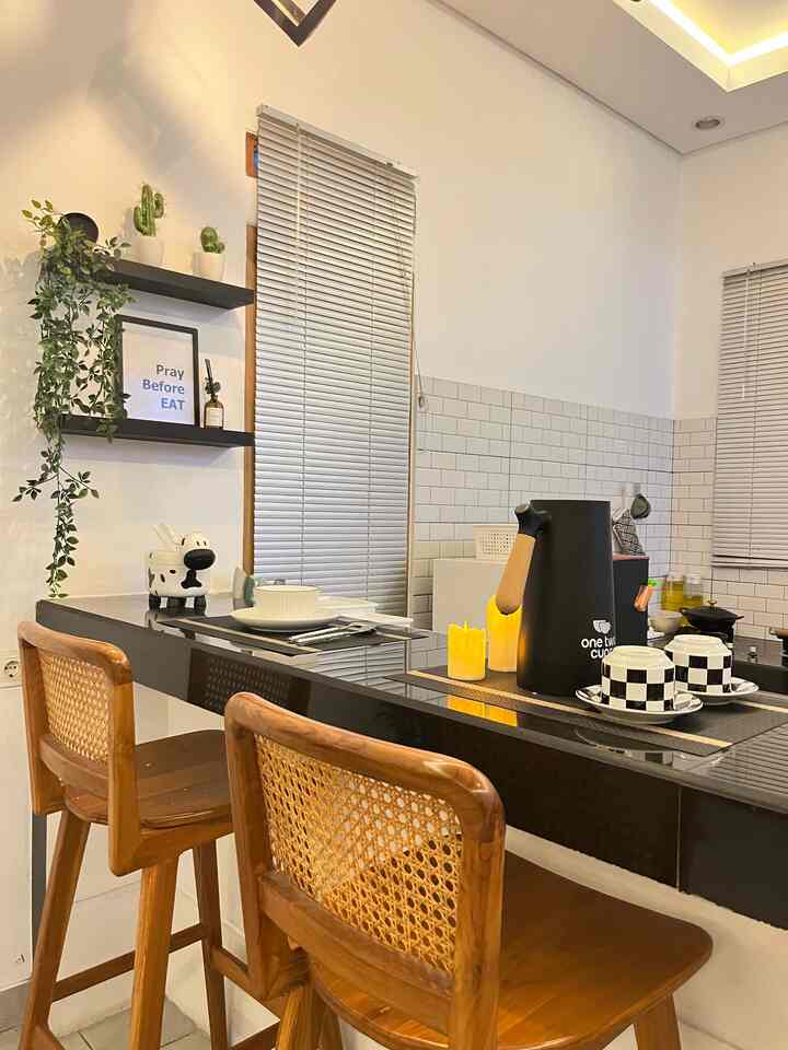 Modern and clean kitchen with white walls and tiles, black glossy dining table, and wood-tone bar stools