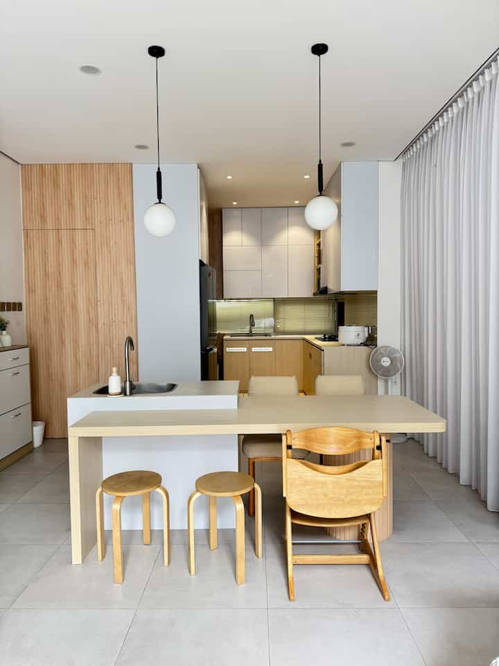 Natural-toned kitchen and dining room featuring wooden dining table and chairs, a clean and cozy space