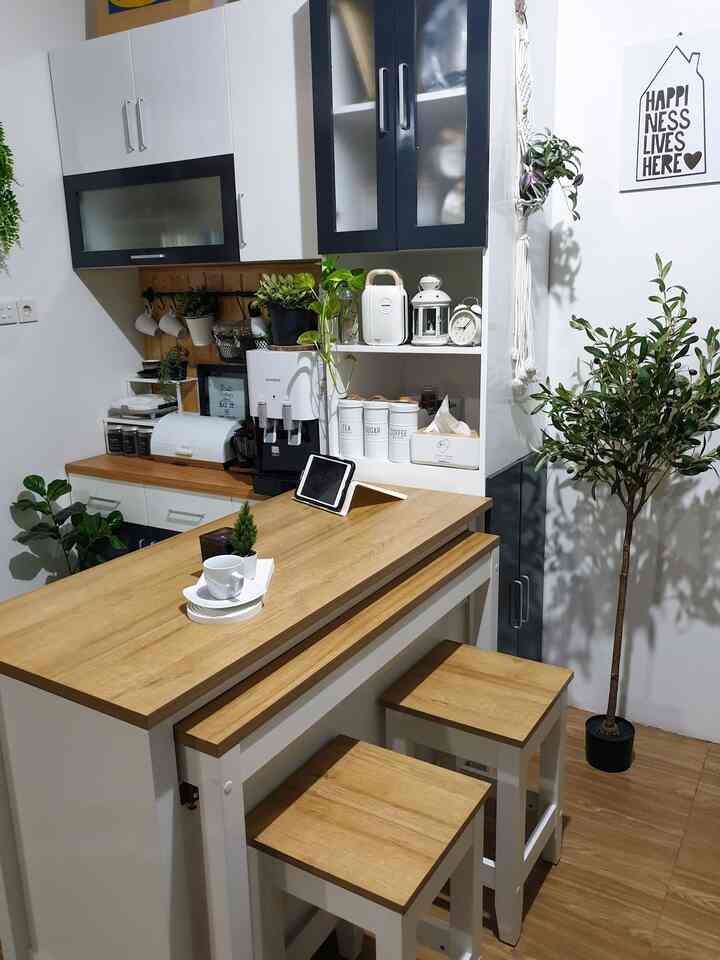 Bright kitchen space with white walls and wood tone dining table, cozy home cafe vibe featuring coffee items and plants