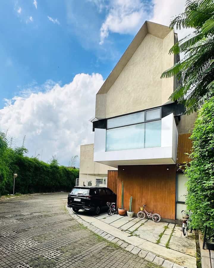Fasad Skandinavia Minimalis 

Rumah ini selesai dibangun tahun 2019, dan dari awal udah punya vibe yang khas—minimalis, hangat, dan nyaman banget. Gaya Skandinavia-nya kerasa dari perpaduan beton ekspos dan aksen kayu yang bikin fasadnya tetap simpel tapi tetap estetik. Ditambah jendela besar yang bisa digeser dengan bingkai abu-abu tua, makin modern sekaligus terang karena cahaya alami gampang masuk.

Bagian depan rumah punya bentuk atap yang nggak biasa, bikin siluet trapesium kelihatan unik. Ada balkon yang sedikit menjorok keluar, jadi ada tambahan space yang menarik. Garasinya juga terbuka, tetap nyambung sama desain fasad yang dominan kayu conwood. Trus, ada taman kecil di dalam yang bikin suasana makin adem, lengkap dengan ayunan putih yang kesannya homey banget.

Ini bukan cuma rumah biasa, rumah ini bener-bener dirancang buat nyaman dan bikin betah. Cocok banget buat yang suka desain simpel tapi tetap elegan!
#Dindingconwood #PagarRumahMinimalis #PagarPutih #CatRumah #KaktusKoboi
#InspirasiFasad #StyleFasad #FasadRumah #NordicHome #TheABChaven