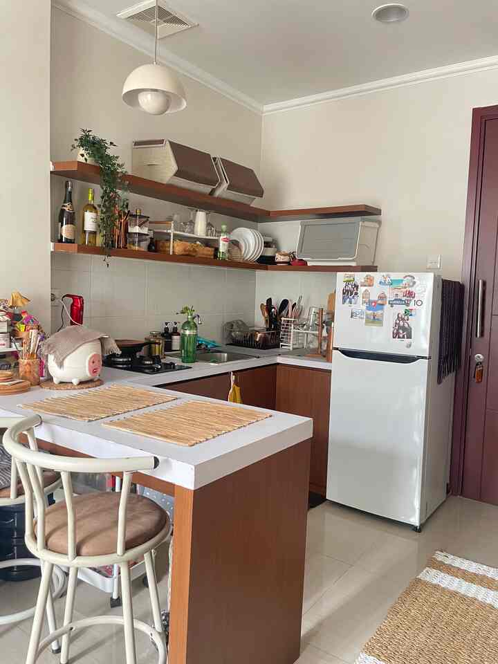 White and brown toned kitchen space featuring dining table, chair, and versatile storage creating cozy atmosphere