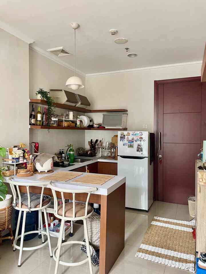 Natural and minimal kitchen and dining space in white and brown tones, featuring open shelving and simple furniture creating an airy atmosphere