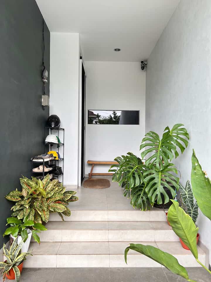 Teras Rumah sekaligus untuk terima tamu sementara yang tidak perlu masuk di rumah kami. Dinding sederhana saja putih dan cat dekoratif washed, namun kami hiasi dengan banyak pot tanaman agar lebih segar dipandang. 
Untuk rak sepatu memang kami prefer terbuka tanpa kabinet khusus karena sepatu dan sendal yang seringkali kotor. Di sebelahnya terdapat sepatu kerja dan helm kerja pak suami.

#TerasRumah #TerasMinimalis #LantaiTeras #KursiTeras #KarpetOutdoor #RakSepatu #Rakhelm #PotTanaman #TanamanTropis #TropicalHouse #RumahModern #Minimalis