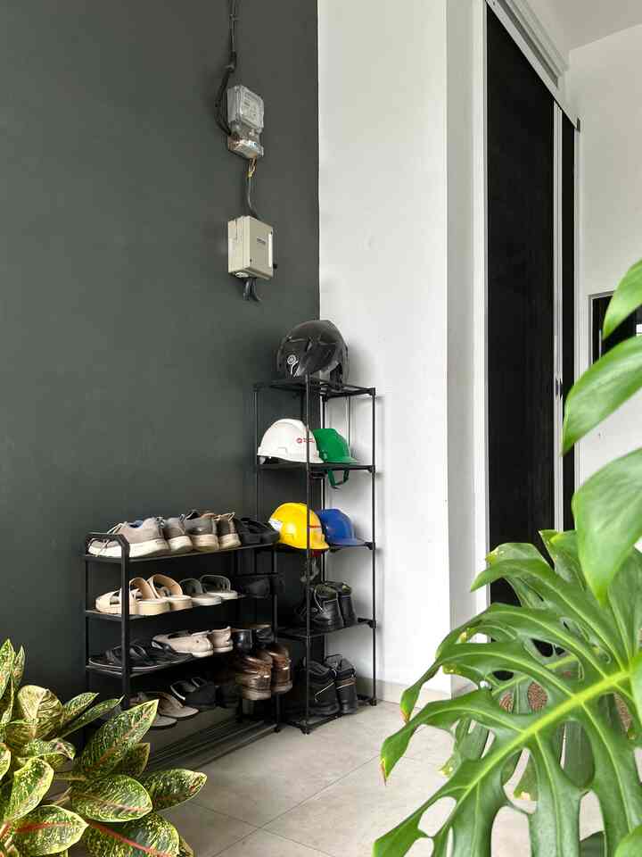 White and black toned entrance featuring shoe racks and helmet storage in a compact and tidy space
