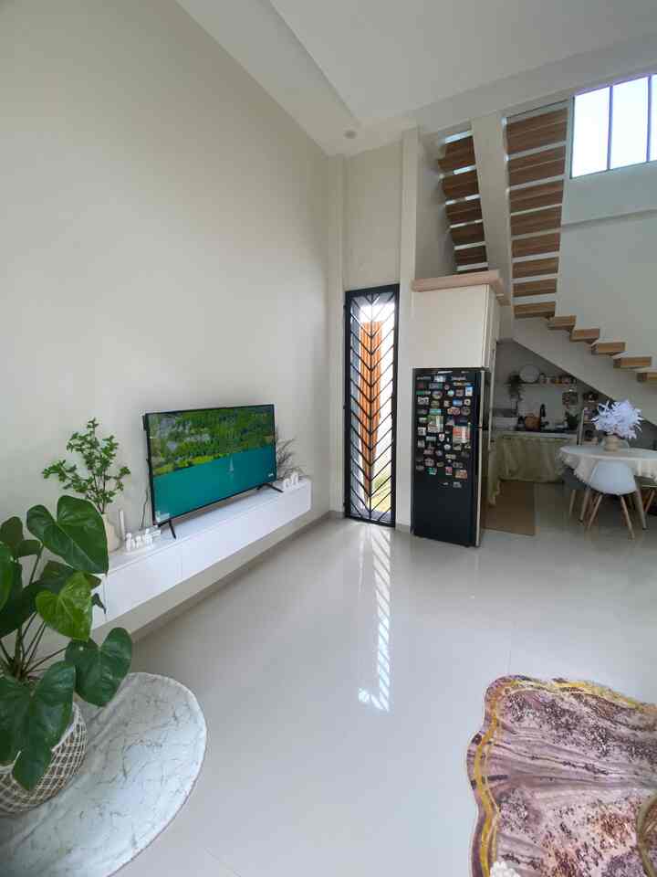 Bright and spacious loft living room with white walls and brown wooden accents, featuring dining area and minimalist decor