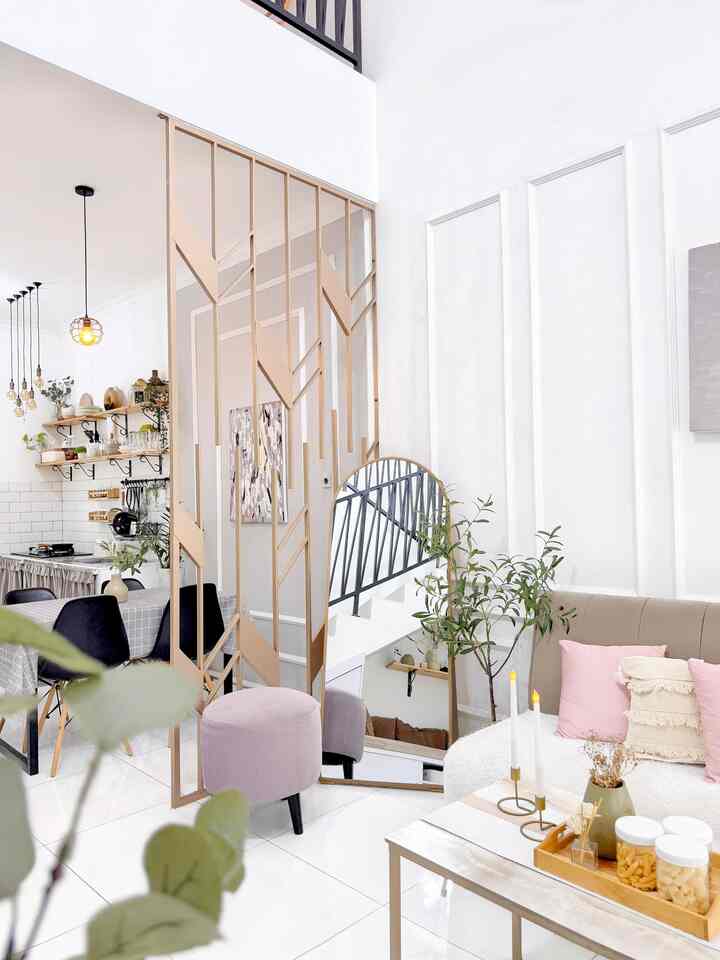 White and beige toned living room featuring pink cushions and a stool in a cozy, natural atmosphere